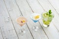 Three ice cold refreshing cocktails on white wooden background. Royalty Free Stock Photo