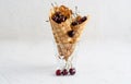 Three ice cream cones filled with cherries in a glass beaker on a light white concrete background Royalty Free Stock Photo