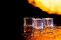 three ice cubes against the background of fire, fire and ice, place under the text Royalty Free Stock Photo