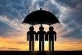 Three icons of little men stand under umbrella together