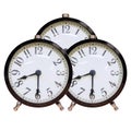 Three identical alarm clocks with white dial and black numbers on an isolated background