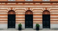 Three Identical Black Doors with Arched Transoms on a Red Brick Building Facade image photo Royalty Free Stock Photo