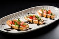 three identical bruschettas on a modern plate, glaze in tiny droplets