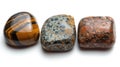 Three identical-sized stones, Tiger's Eye, Jasper, and Obsidian, aligned side by side, revealing their unique