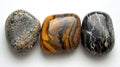 Three identical-sized stones, Tiger's Eye, Jasper, and Obsidian, aligned side by side, revealing their unique