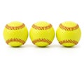 Three identical softballs with red stitching in a row Royalty Free Stock Photo