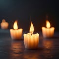 Three illuminated tea light candles with soft orange flames on a dark surface glow Royalty Free Stock Photo