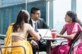 Three Indian business people talking during break at work Royalty Free Stock Photo