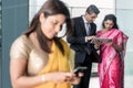 Three Indian business people using modern devices indoors