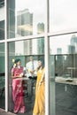 Indian employees sticking reminders on glass wall in the office Royalty Free Stock Photo