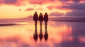 Three individuals stroll along a beach at sunset under a pink sky. Royalty Free Stock Photo