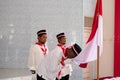 three Indonesian citizens kissing the national flag