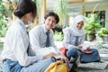 three Indonesian high school students smile while studying in groups sitting on the floor Royalty Free Stock Photo