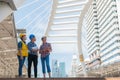 Three industrial engineer standing and looking to right side wear safety helmet with holding inspection and digital tablet Royalty Free Stock Photo