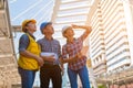 Three industrial engineer wear safety helmet and holding tablet engineering working and talking