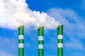 Three Industrial smoke pipes from chimney on blue cloudy sky Royalty Free Stock Photo