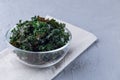Three ingredient baked green kale chips with sea salt and olive oil, in glass bowl, horizontal, copy space