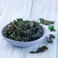 Three ingredient baked green kale chips with sea salt and olive oil, in gray bowl, square format
