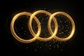 Three interlocking golden rings with sparkling light trails Royalty Free Stock Photo