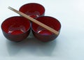 Three Japanese lacquer bowls and wooden chopsticks in front of a Royalty Free Stock Photo