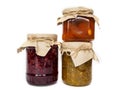 Three jars of different jam on a white background