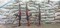 Three Kalashnikovs standing near sandbagged fortifications. AK-74 outdoor