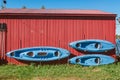 Three kayaks and paddles are hanging on the wall to dry.