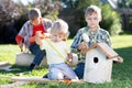 Three kids boys brothers making wooden birdhouse by hands Royalty Free Stock Photo