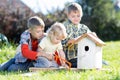 Three kids boys brothers making wooden birdhouse by hands Royalty Free Stock Photo