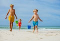 Three kids boys, girl run from ocean with bucket play on a beach Royalty Free Stock Photo