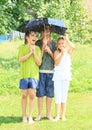 Three kids with broken black umbrella