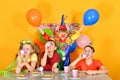 Three kids drink juice for a clownÃ¢â¬â¢s birthday. Royalty Free Stock Photo