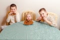 Three kids eating pancakes at the table at home Royalty Free Stock Photo