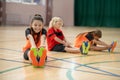 Three kids exercising in the gym and stretching froward Royalty Free Stock Photo