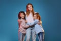 three kids girls standing together on blue background Royalty Free Stock Photo