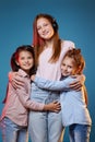 three kids girls standing together on blue background Royalty Free Stock Photo