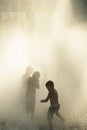 Three kids playing in a fountain