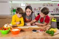 Three kids reading the cook book, making the dinner Royalty Free Stock Photo