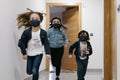 Three kids running into the street wearing masks Royalty Free Stock Photo