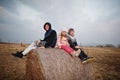 Three kids sitting on haycock at field Royalty Free Stock Photo