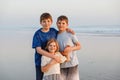 Three kids standing on beach at sunset. happy family, two school boys and one little preschool girl. Siblings having fun Royalty Free Stock Photo