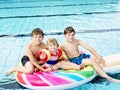 Three kids, two boys and toddler girl splash in an outdoors swimming pool in summer. Happy children, brothers and sister Royalty Free Stock Photo