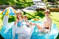 Three kids, two boys and toddler girl splash in an outdoors swimming pool in summer. Happy children, brothers and sister Royalty Free Stock Photo