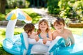 Three kids, two boys and toddler girl splash in an outdoors swimming pool in summer. Happy children, brothers and sister Royalty Free Stock Photo