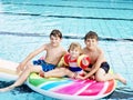 Three kids, two boys and toddler girl splash in an outdoors swimming pool in summer. Happy children, brothers and sister Royalty Free Stock Photo