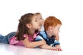 Three kids watching and lying on floor Royalty Free Stock Photo
