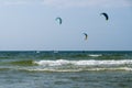 Three kiters ride on the waves of sea Royalty Free Stock Photo
