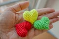 Three knitted hearts in open hand. Love concept. Romance background. Three small yarn hearts. Love symbol.