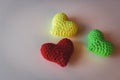 Three knitted hearts on white background. Love concept. Romance background. Three small yarn hearts. Love symbol.