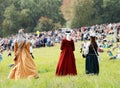 Three ladies in long vintage dress walking away